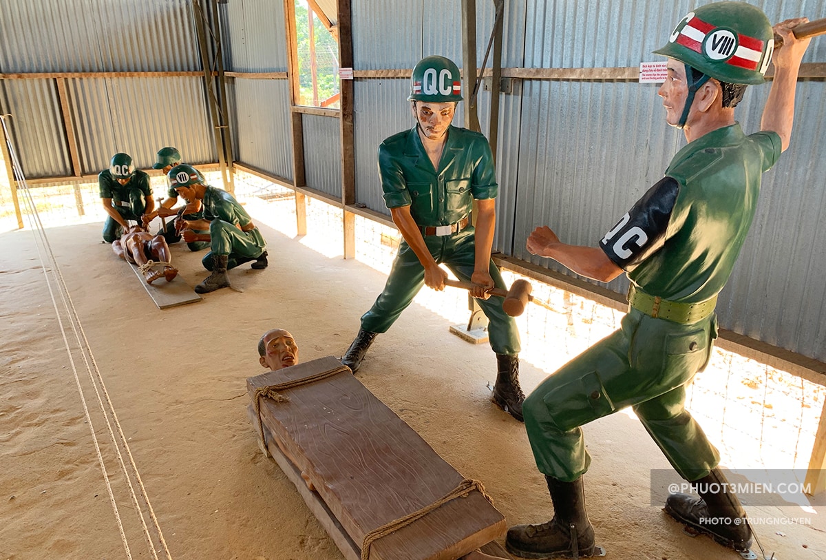 This image shows a fake prisoner figure getting his kneecaps chiseled by two guard figures.